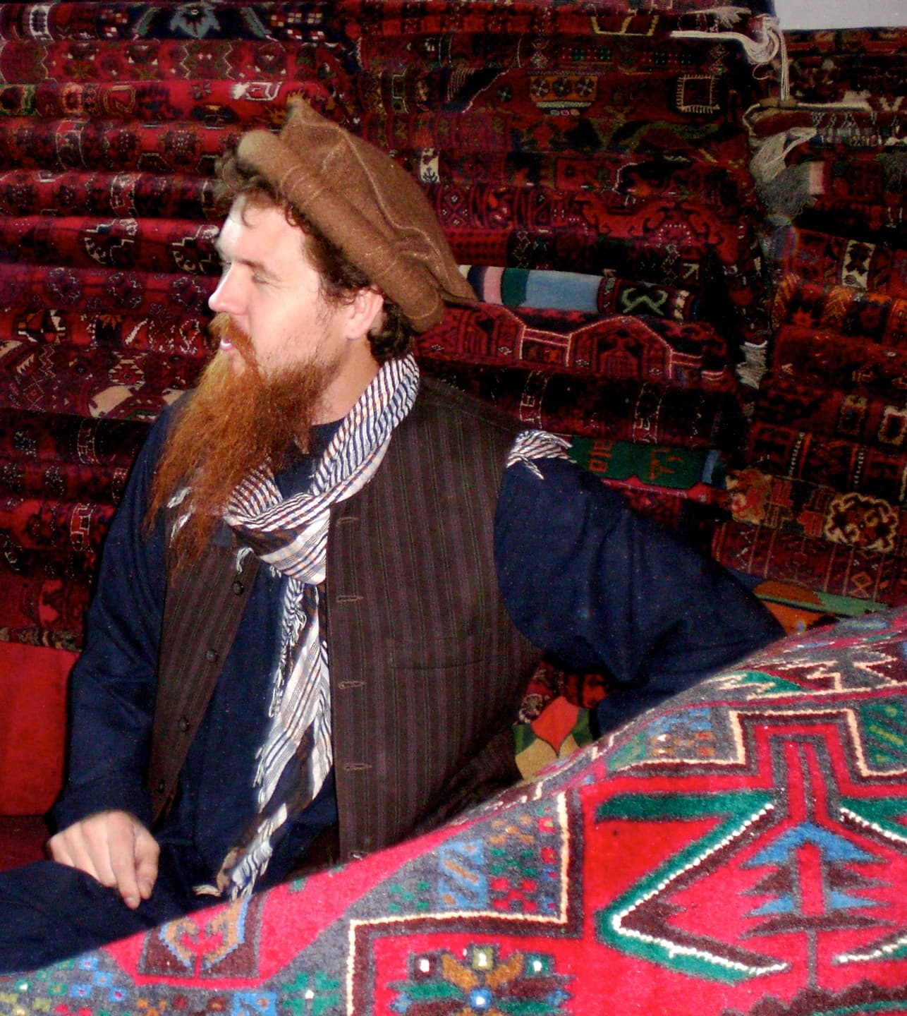 A carpet merchant displaying patterned rugs in Nangarhar, Afghanistan