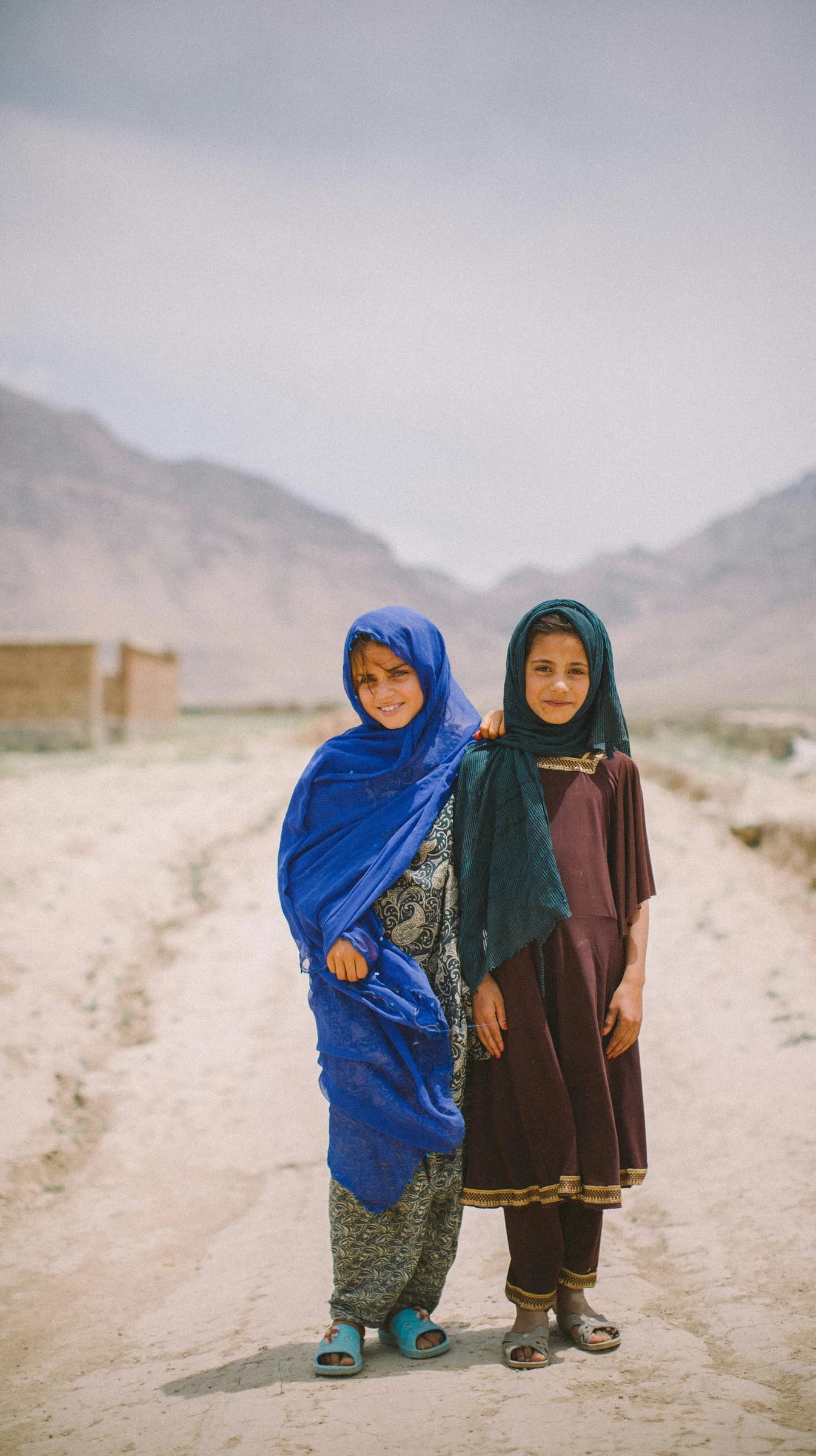 Two girls standing on a village road in Afghanistan