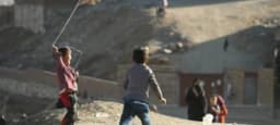 Children flying kites on a hill in Afghanistan