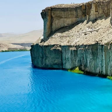 Pale cliffs above a deep blue Afghan lake
