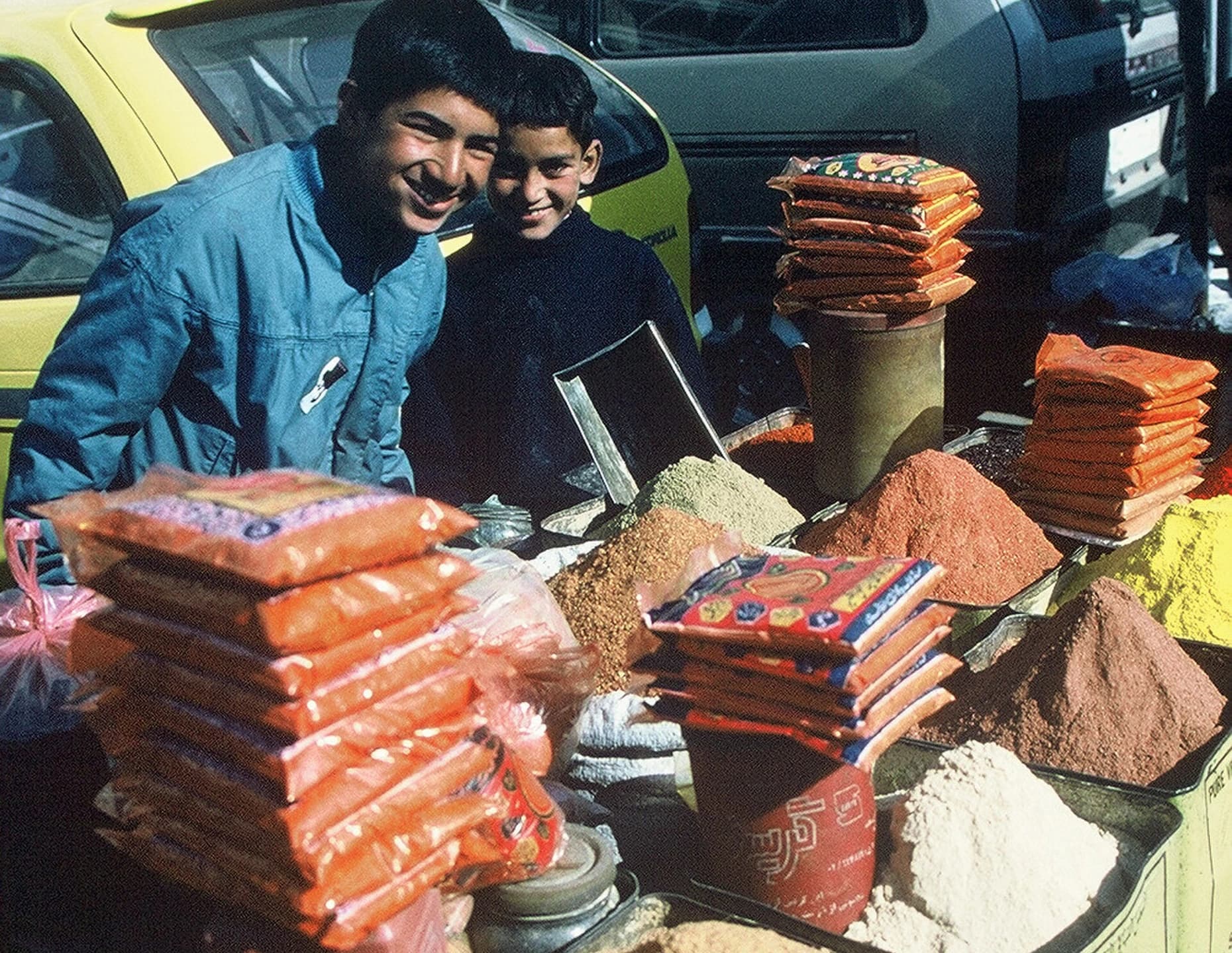 A young spice seller at an Afghan market stall
