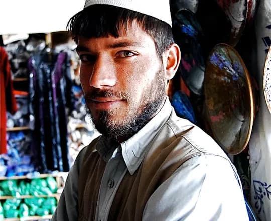 A pottery merchant in Istalif wearing a cap and waistcoat