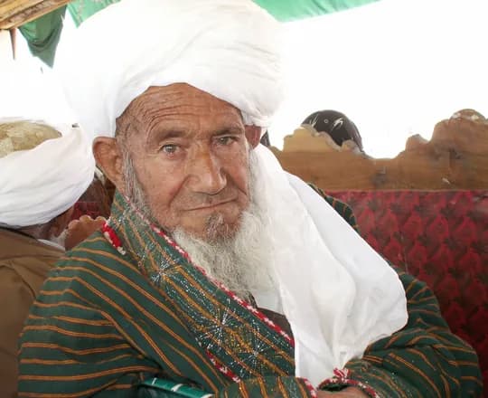 An elder in a white turban and striped chapan coat in Chaghcharan, Ghor Province, 2007
