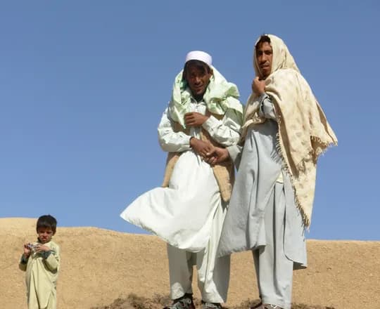 Two friends wrapped in wool shawls on a hillside in Ghor Province, 2007