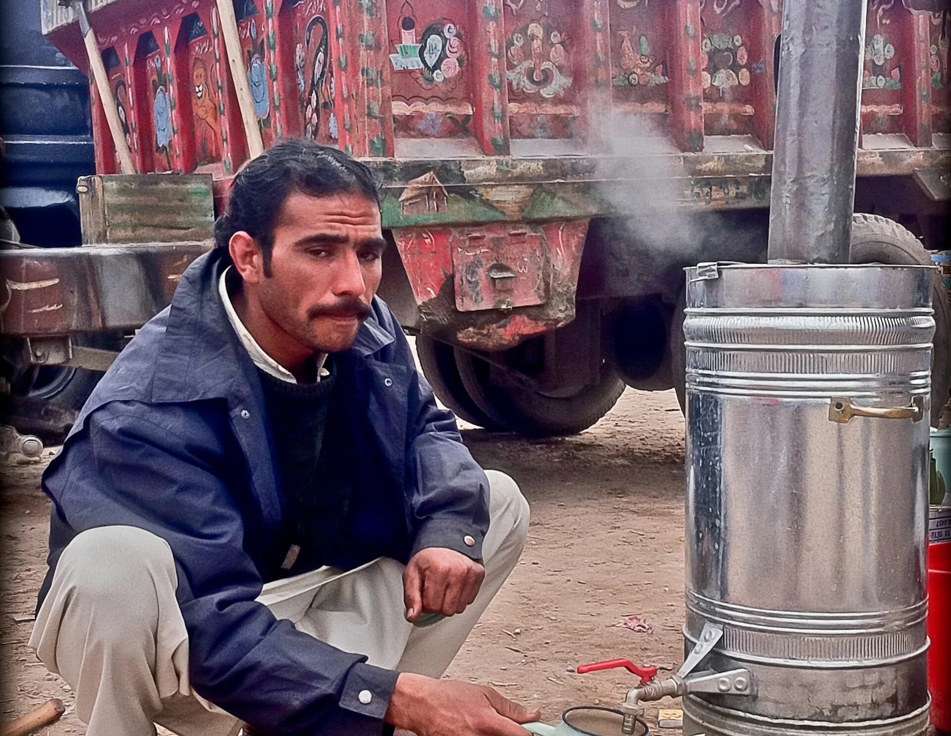 A tea seller beside a steaming samovar in Jalalabad