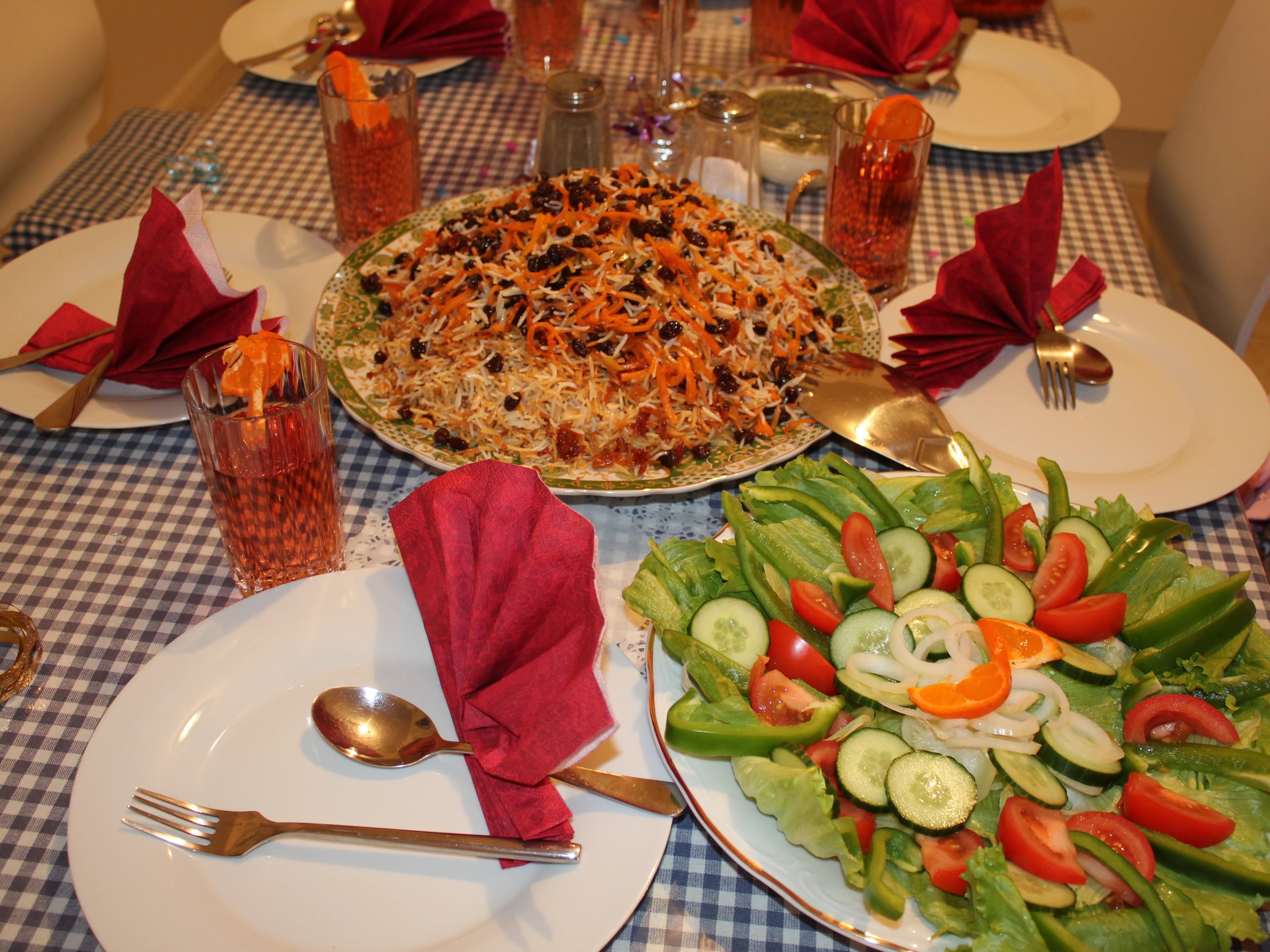 An Afghan table set with palaw, salads and accompaniments