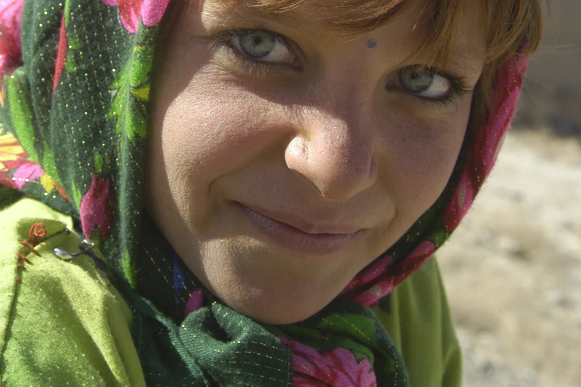A young Nuristani girl in a pink and green headscarf, photographed in Kabul in 2002