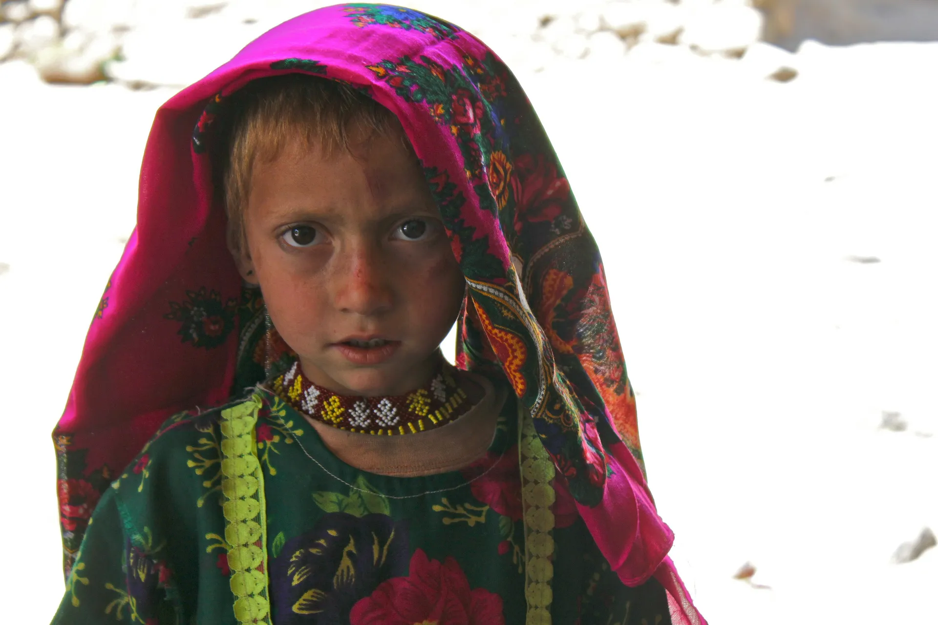 A young Pashai girl in a brightly patterned headscarf and beaded necklace in Dara-i-Nur, Nangarhar, 2010