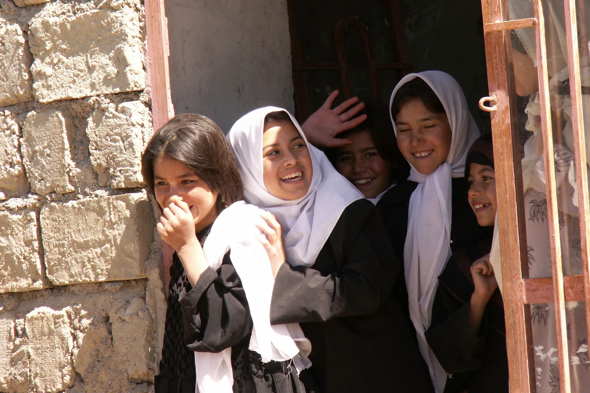 Schoolgirls in white headscarves at a school doorway in Chaghcharan, Ghor Province, 2007