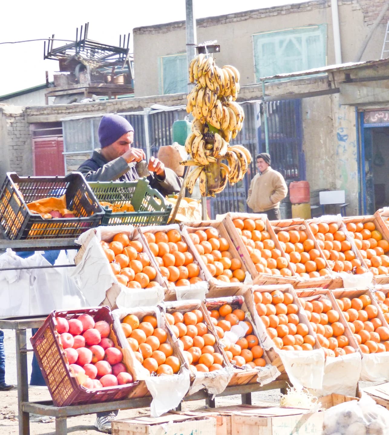 A fruit seller and produce stall in a Kabul neighbourhood market