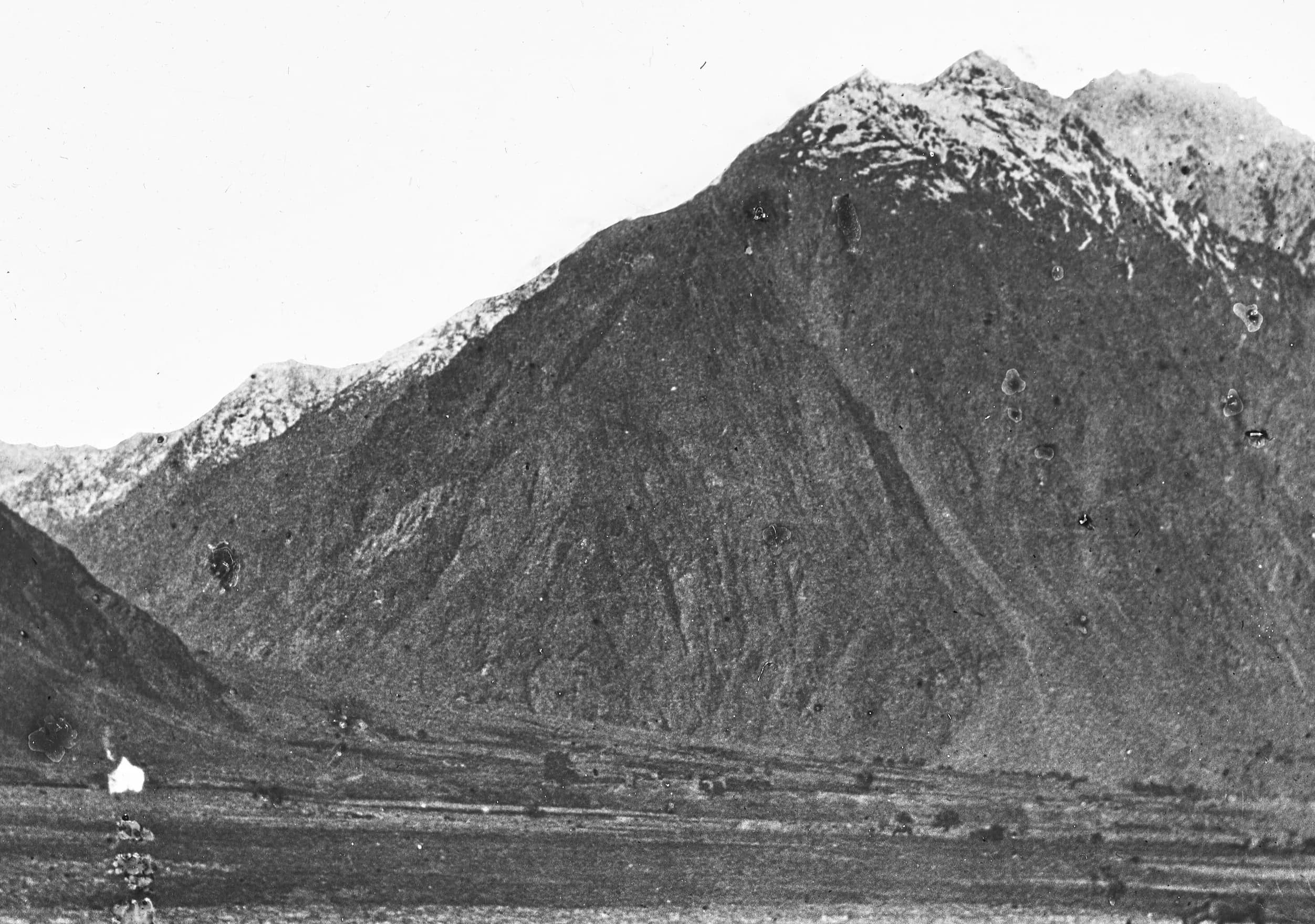 Snow-dusted mountains rising above the valley floor at Sarhad, at the head of the Wakhan, photographed by Guillaume Capus in 1887